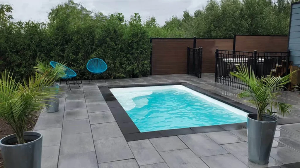Finished Ontario fiberglass pool installation with patio and fencing