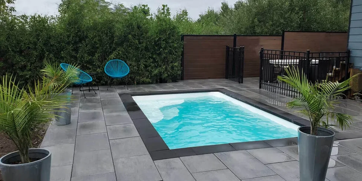 Finished Ontario fiberglass pool installation with patio and fencing