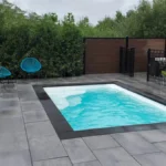 Finished Ontario fiberglass pool installation with patio and fencing